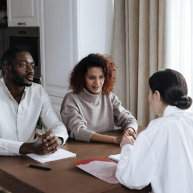 Man and woman discussing documents with a social worker at home.
